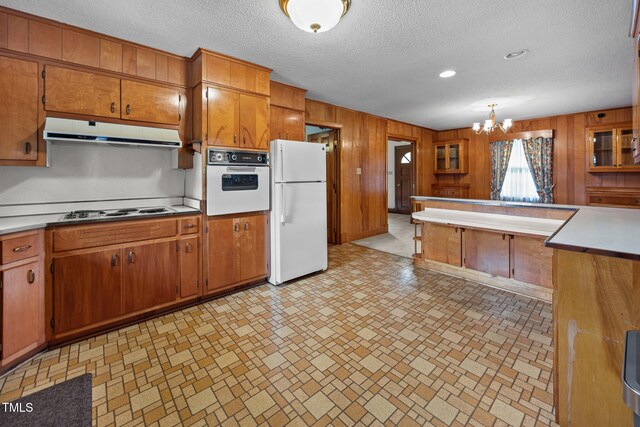 4804 Spring Forest Rd, Raleigh, NC 27616 - kitchen with white appliances, ventilation hood, brown cabinetry, wood walls, and light countertops