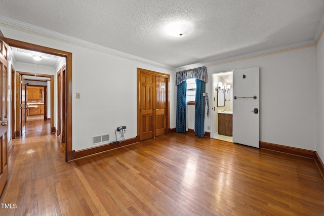 4804 Spring Forest Rd, Raleigh, NC 27616 - unfurnished bedroom with a textured ceiling, wood finished floors, ornamental molding, and a closet