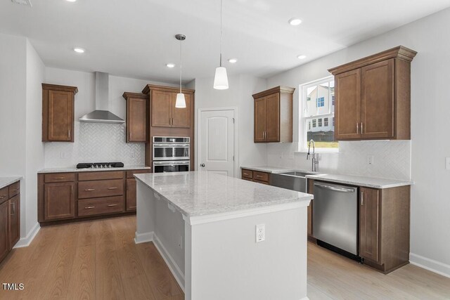 257 N Maple Walk Dr Unit 218, Garner, NC 27529 - kitchen with stainless steel appliances, wall chimney exhaust hood, a sink, light wood finished floors, and recessed lighting