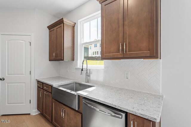 257 N Maple Walk Dr Unit 218, Garner, NC 27529 - kitchen featuring stainless steel dishwasher, a sink, light stone counters, and backsplash