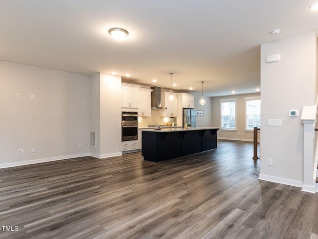2008 Van Hook Ln, Apex, NC 27502 - kitchen with appliances with stainless steel finishes, wall chimney range hood, recessed lighting, dark wood finished floors, and light countertops