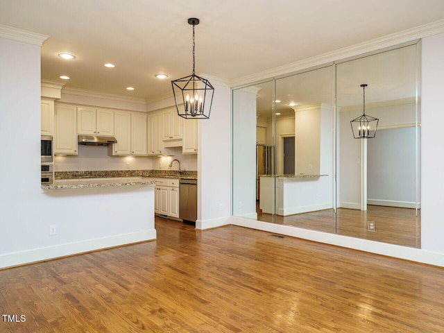3339 Ridgecrest Ct, Raleigh, NC 27607 - kitchen featuring a chandelier, crown molding, under cabinet range hood, appliances with stainless steel finishes, and wood finished floors