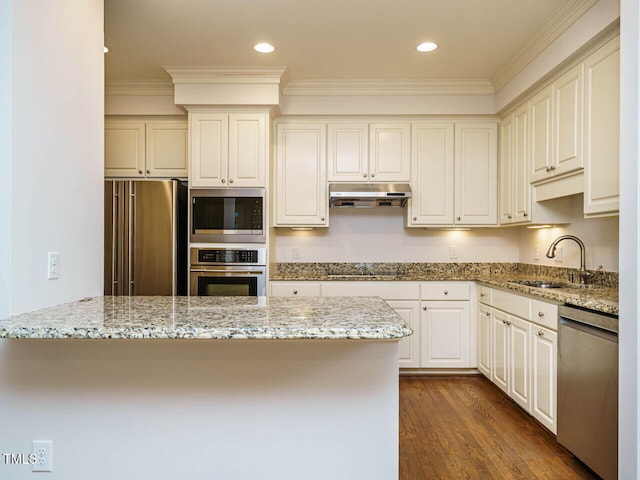 3339 Ridgecrest Ct, Raleigh, NC 27607 - kitchen with appliances with stainless steel finishes, under cabinet range hood, crown molding, light stone counters, and dark wood finished floors