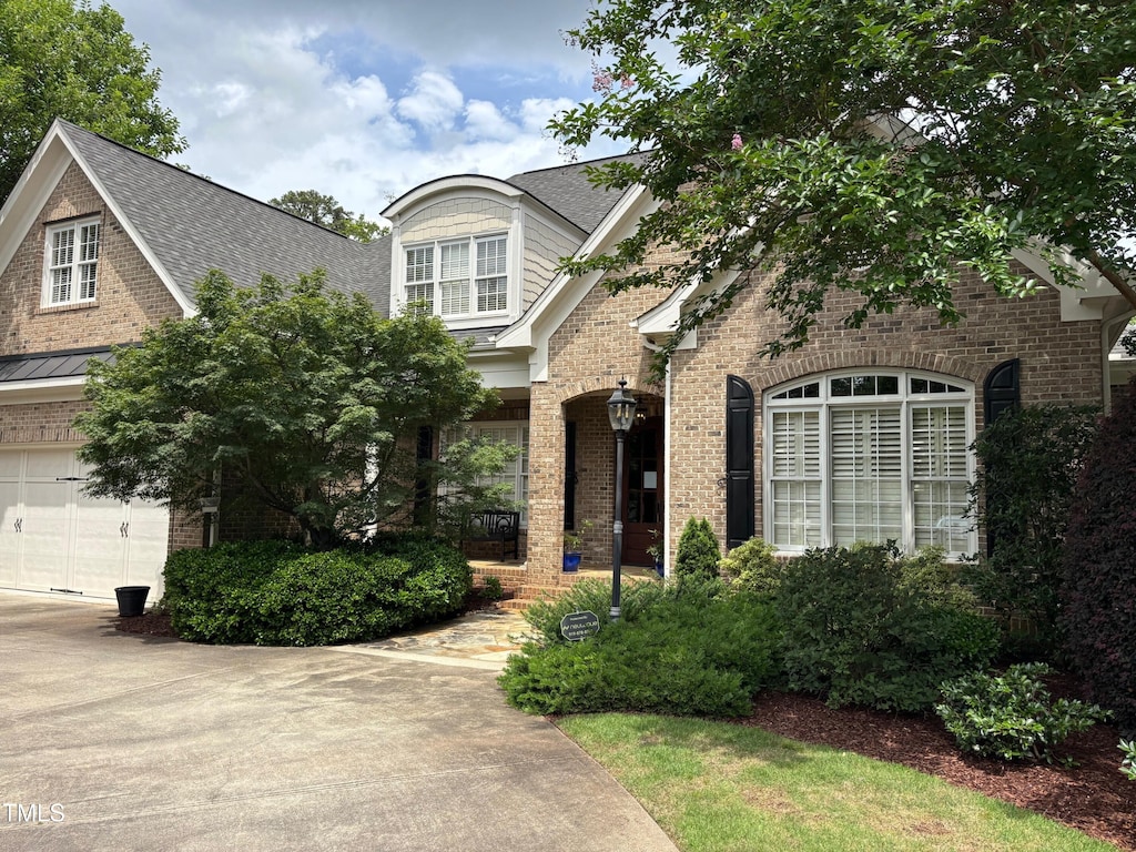1210 Brooks Ave, Raleigh, NC 27607 - view of front of home featuring brick siding, a garage, and roof with shingles