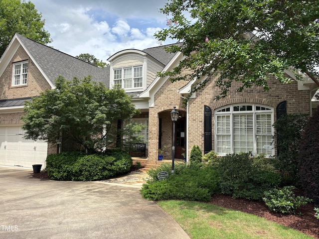 1210 Brooks Ave, Raleigh, NC 27607 - view of front of home featuring brick siding, a garage, and roof with shingles