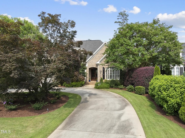 1210 Brooks Ave, Raleigh, NC 27607 - view of front of property featuring curved driveway, brick siding, and a front lawn