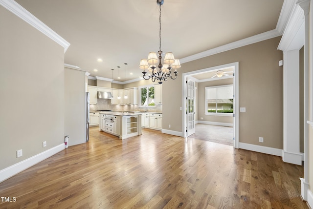 1210 Brooks Ave, Raleigh, NC 27607 - kitchen featuring range hood, crown molding, white cabinets, a chandelier, and baseboards