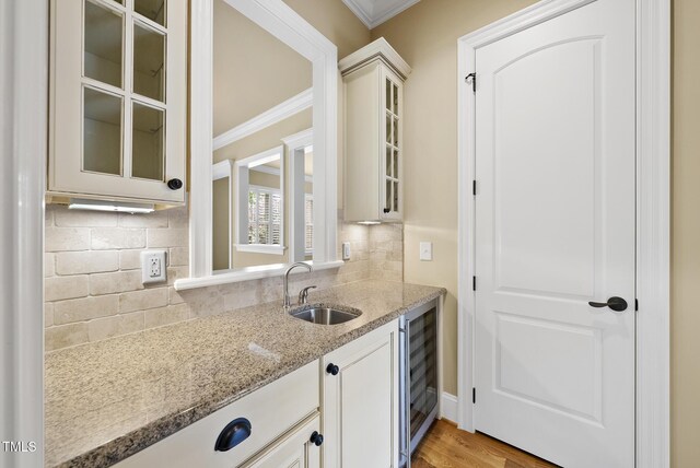 1210 Brooks Ave, Raleigh, NC 27607 - kitchen with ornamental molding, beverage cooler, a sink, glass insert cabinets, and light stone counters