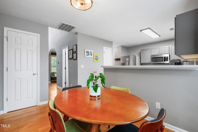 202 Stonecreek Dr, Apex, NC 27539 - dining area with arched walkways, light wood-style floors, and baseboards