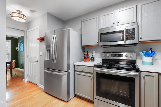 202 Stonecreek Dr, Apex, NC 27539 - kitchen featuring appliances with stainless steel finishes, gray cabinetry, light wood-type flooring, and light countertops