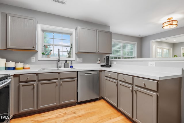 202 Stonecreek Dr, Apex, NC 27539 - kitchen featuring stainless steel appliances, gray cabinetry, a peninsula, and a sink