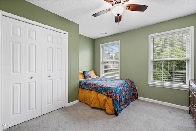 202 Stonecreek Dr, Apex, NC 27539 - bedroom with baseboards, a closet, carpet flooring, a ceiling fan, and a textured ceiling