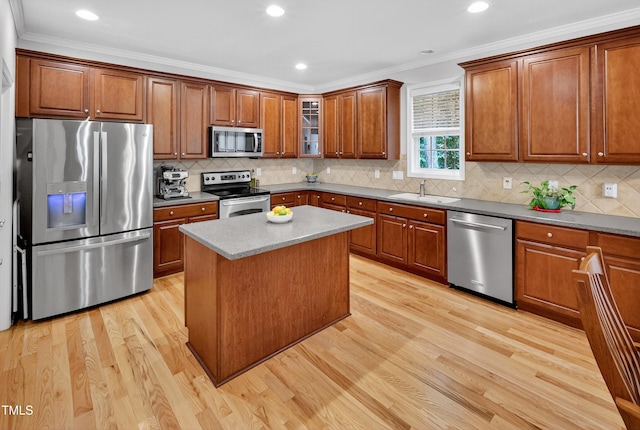 1437 Lindenberg Sq, Wake Forest, NC 27587 - kitchen with stainless steel appliances, light wood-style floors, brown cabinets, ornamental molding, and recessed lighting