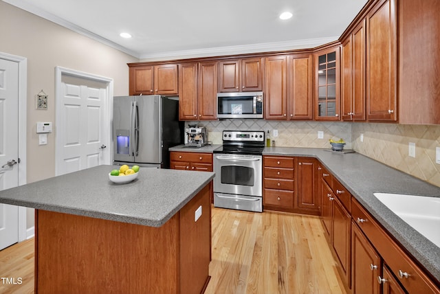 1437 Lindenberg Sq, Wake Forest, NC 27587 - kitchen featuring appliances with stainless steel finishes, ornamental molding, light wood-type flooring, brown cabinets, and glass insert cabinets