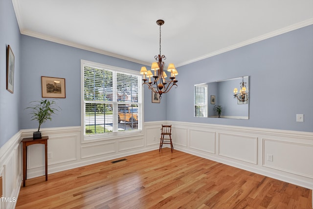 1437 Lindenberg Sq, Wake Forest, NC 27587 - spare room featuring a chandelier, light wood-style floors, ornamental molding, and wainscoting