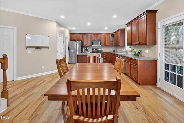 1437 Lindenberg Sq, Wake Forest, NC 27587 - kitchen with stainless steel appliances, crown molding, light wood-style floors, backsplash, and a kitchen island