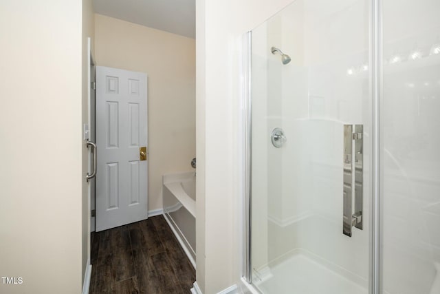 6737 Vernie Dr, Raleigh, NC 27603 - bathroom featuring a shower stall, wood finished floors, a bath, and baseboards