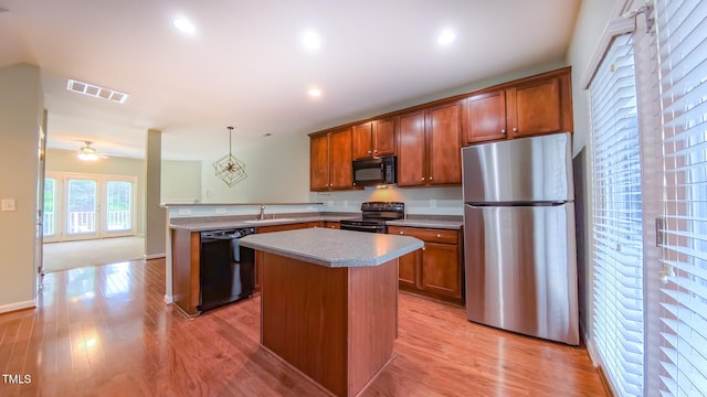 151 Braeside Ct, Cary, NC 27519 - kitchen with black appliances, a sink, a peninsula, a kitchen island, and brown cabinets