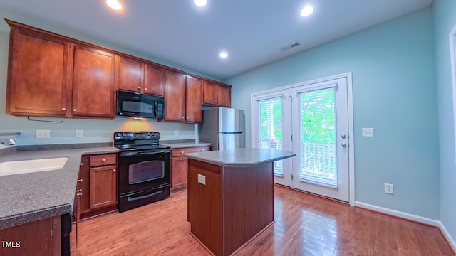 151 Braeside Ct, Cary, NC 27519 - kitchen featuring black appliances, a sink, a kitchen island, light wood finished floors, and recessed lighting