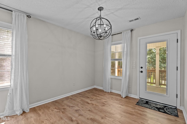 428 Long Branch Dr, Lacrosse, VA 23950 - doorway with a chandelier, light wood finished floors, baseboards, and a textured ceiling