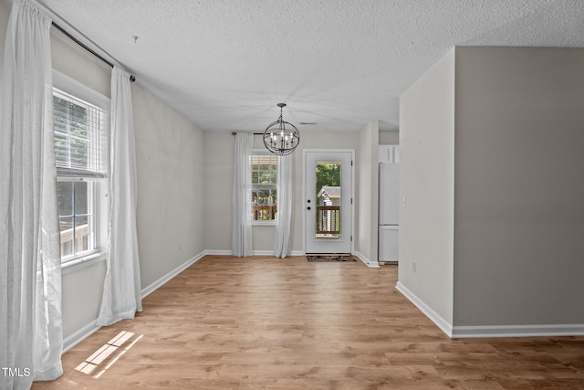 428 Long Branch Dr, Lacrosse, VA 23950 - unfurnished dining area with a chandelier, light wood-style floors, a textured ceiling, and baseboards