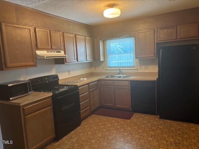 708 Old Barn Ave, Durham, NC 27704 - kitchen featuring black appliances, a sink, under cabinet range hood, light countertops, and a textured ceiling