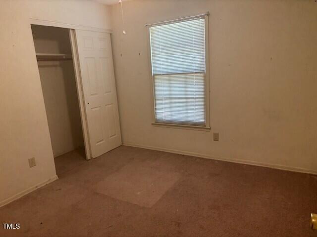 708 Old Barn Ave, Durham, NC 27704 - unfurnished bedroom featuring carpet floors, a closet, and baseboards