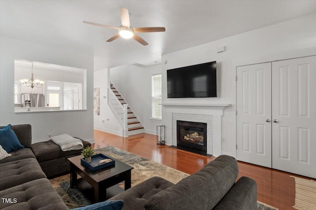 4605 All Points View Way, Raleigh, NC 27614 - living area featuring stairway, wood finished floors, a ceiling fan, a chandelier, and a brick fireplace
