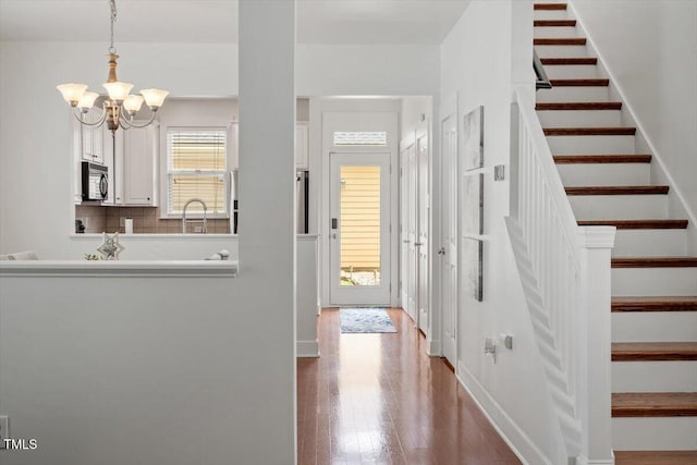 4605 All Points View Way, Raleigh, NC 27614 - hall with stairway, a sink, a chandelier, and wood finished floors