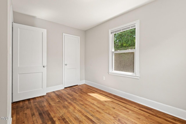 1411 Hudson Ave, Durham, NC 27705 - unfurnished bedroom with wood finished floors and baseboards