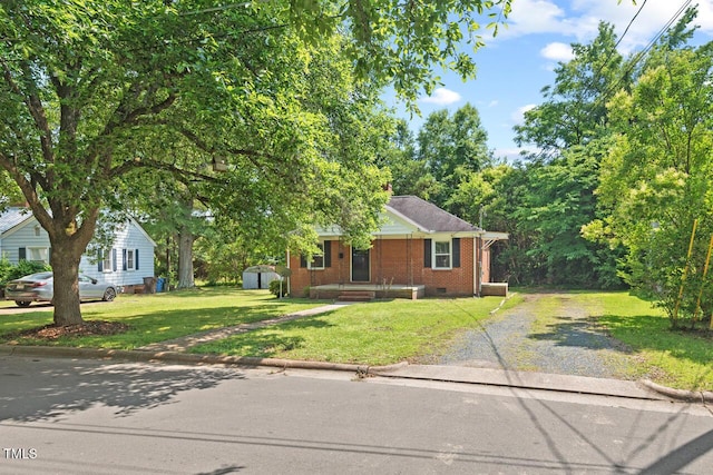 1411 Hudson Ave, Durham, NC 27705 - view of front facade with gravel driveway, brick siding, a front lawn, and crawl space