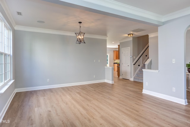12320 Tetons Ct, Durham, NC 27703 - unfurnished room featuring light wood-style flooring, arched walkways, stairs, crown molding, and a chandelier