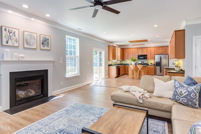 12320 Tetons Ct, Durham, NC 27703 - living area with light wood-style flooring, ornamental molding, a ceiling fan, recessed lighting, and a glass covered fireplace