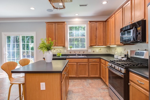 12320 Tetons Ct, Durham, NC 27703 - kitchen featuring stainless steel gas stove, black microwave, dark countertops, healthy amount of natural light, and ornamental molding