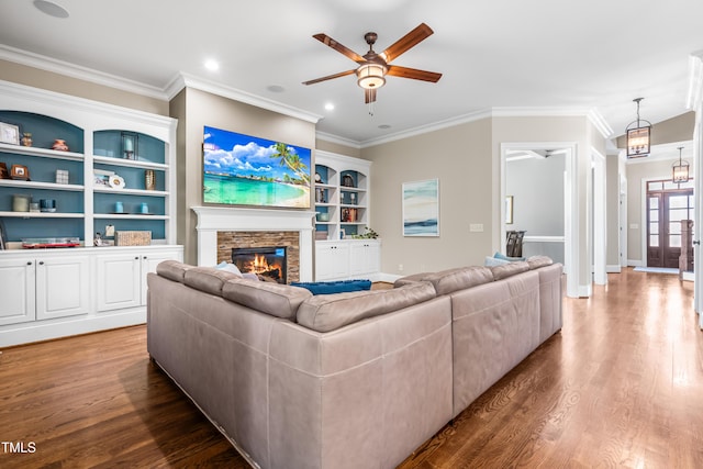 2538 Tuffeto, Apex, NC 27502 - living area with ceiling fan, wood finished floors, a stone fireplace, ornamental molding, and baseboards