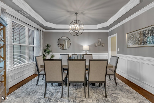 3111 Virginia Pine Ln, Apex, NC 27539 - dining area with a chandelier, a raised ceiling, crown molding, wood finished floors, and a decorative wall