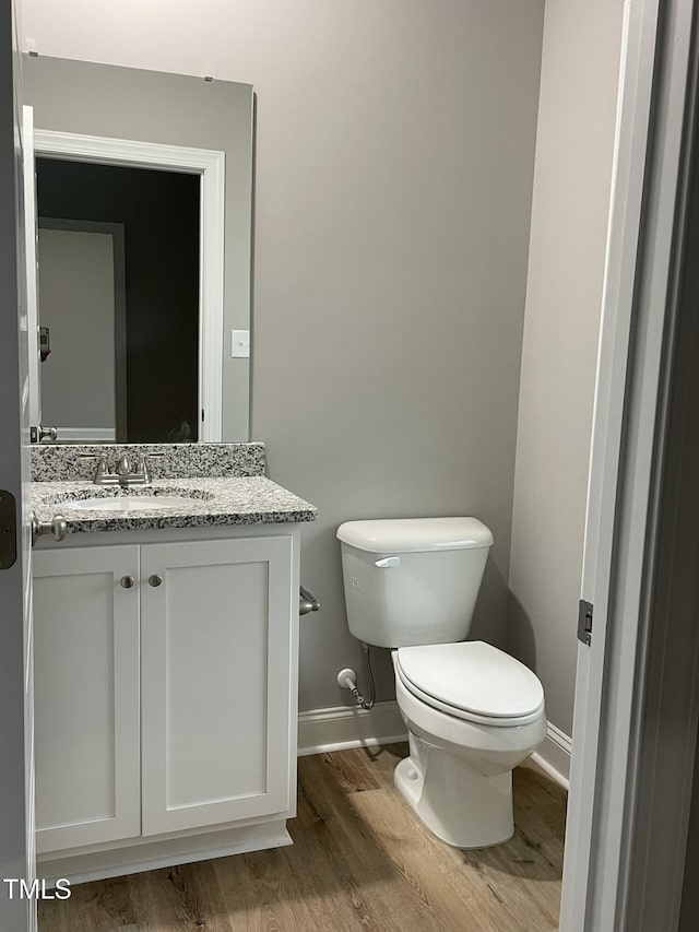 268 Busterfield Ct, Benson, NC 27504 - half bath featuring baseboards, wood finished floors, vanity, and toilet