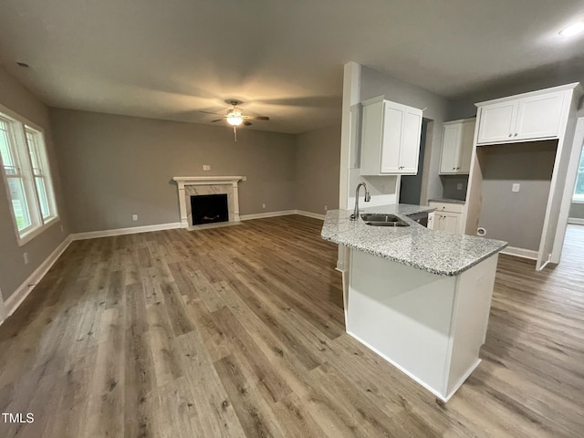268 Busterfield Ct, Benson, NC 27504 - kitchen with a sink, ceiling fan, white cabinets, light stone countertops, and light wood-style flooring
