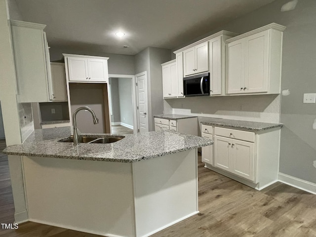 268 Busterfield Ct, Benson, NC 27504 - kitchen featuring stainless steel microwave, a sink, wood finished floors, stone counters, and baseboards