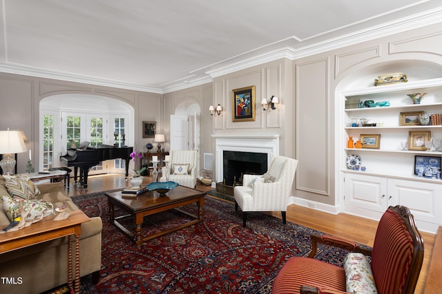3307 Devon Rd, Durham, NC 27707 - living room with arched walkways, ornamental molding, a decorative wall, a fireplace, and wood finished floors