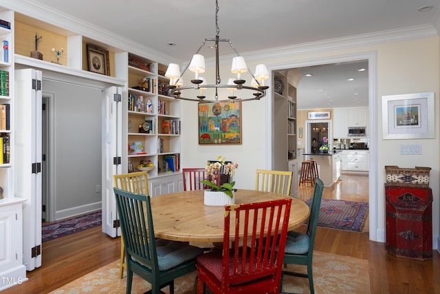 3307 Devon Rd, Durham, NC 27707 - dining area with a chandelier, wood finished floors, crown molding, recessed lighting, and built in shelves