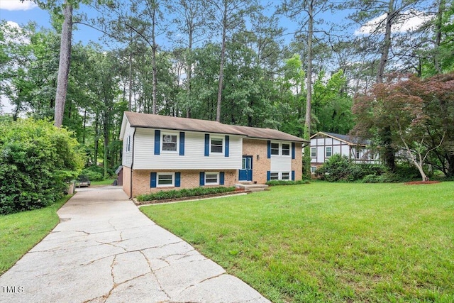 1109 Buckingham Rd, Garner, NC 27529 - bi-level home with driveway, a front lawn, brick siding, and view of wooded area