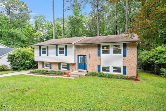1109 Buckingham Rd, Garner, NC 27529 - split foyer home featuring a front yard, view of wooded area, and brick siding