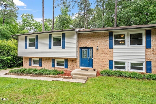 1109 Buckingham Rd, Garner, NC 27529 - bi-level home featuring a front lawn, brick siding, and view of scattered trees
