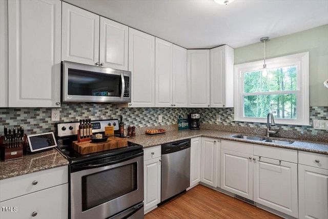 1109 Buckingham Rd, Garner, NC 27529 - kitchen featuring appliances with stainless steel finishes, a sink, backsplash, and white cabinets