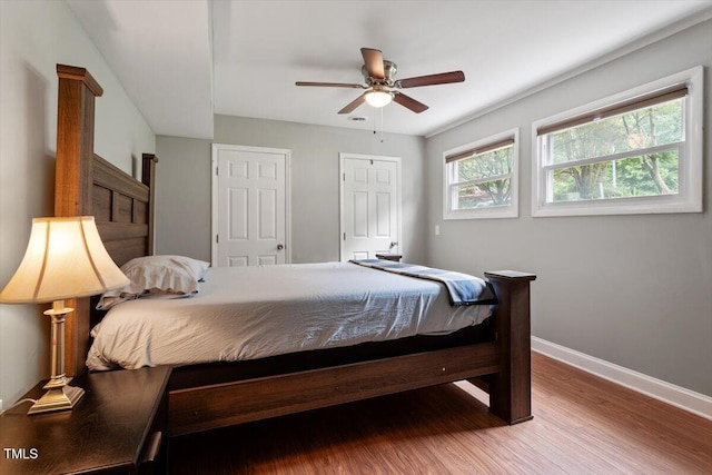 1109 Buckingham Rd, Garner, NC 27529 - bedroom with baseboards, wood finished floors, two closets, and ceiling fan