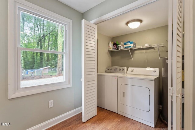 1109 Buckingham Rd, Garner, NC 27529 - laundry room featuring washing machine and clothes dryer, light wood-style flooring, and baseboards