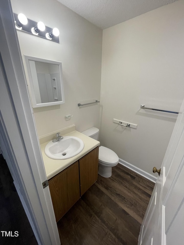 3522 Ivy Commons Dr Unit 101, Raleigh, NC 27606 - bathroom with vanity, wood finished floors, toilet, and a textured ceiling