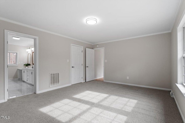 4720 Brigadoon Dr, Durham, NC 27705 - unfurnished bedroom featuring carpet, crown molding, baseboards, and connected bathroom