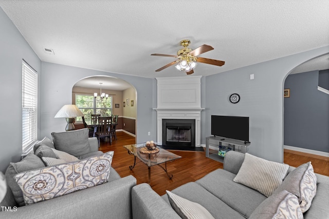 4221 Ivy Hill Rd, Raleigh, NC 27616 - living area featuring arched walkways, wood finished floors, a textured ceiling, ceiling fan, and a fireplace